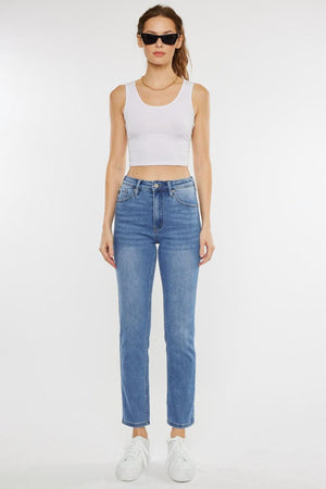 a woman wearing a white tank top and jeans