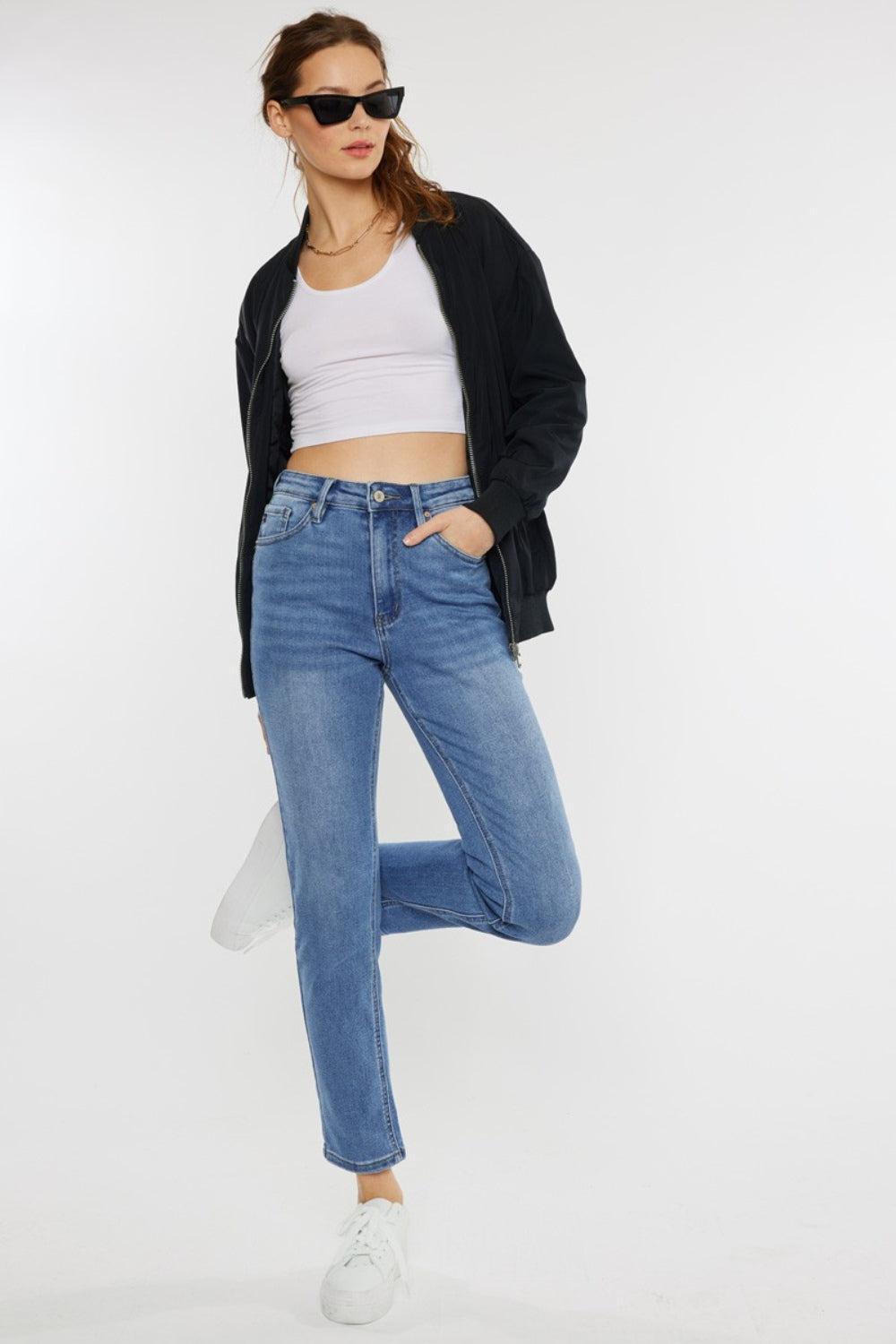 a woman in a white top and jeans posing for a picture