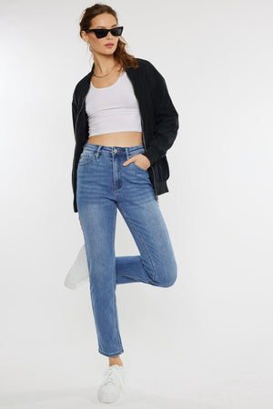 a woman in a white top and jeans posing for a picture