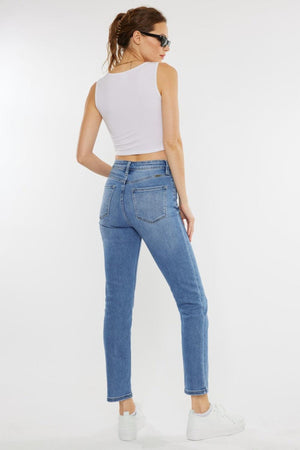 a woman wearing a white tank top and jeans