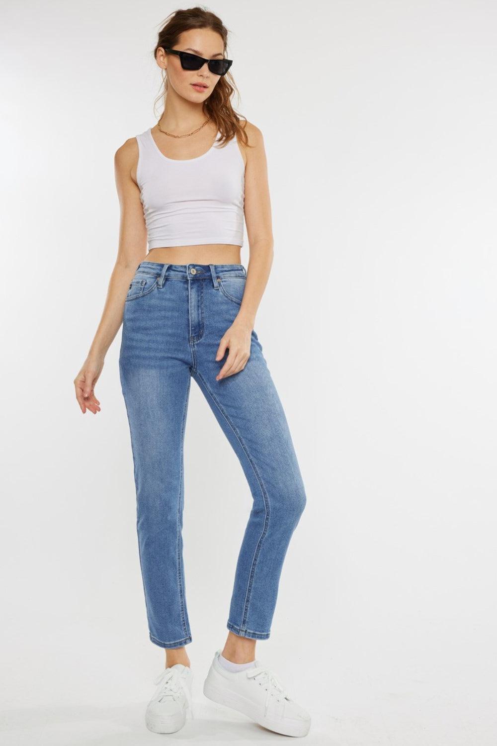 a woman wearing a white tank top and jeans