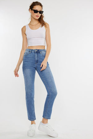 a woman wearing a white tank top and jeans