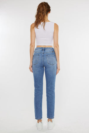 a woman in a white tank top and jeans