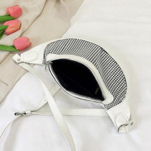 a white purse sitting on top of a bed