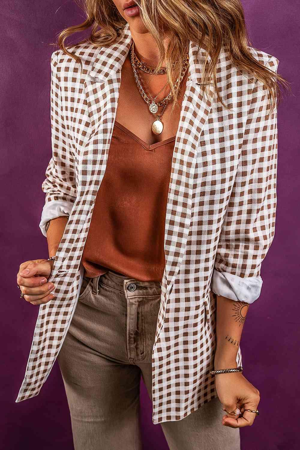 a woman wearing a white and brown checkered blazer