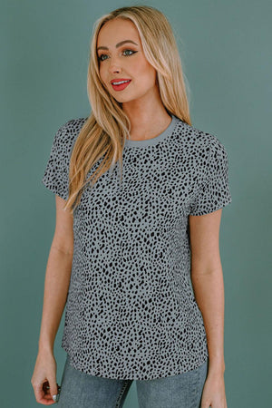 a woman wearing a black and white leopard print top