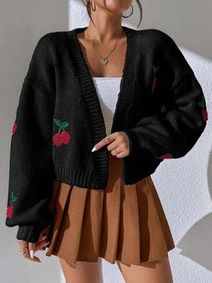 a woman wearing a black cardigan sweater and a brown pleated skirt