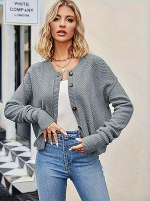 a woman wearing a gray cardigan sweater and jeans