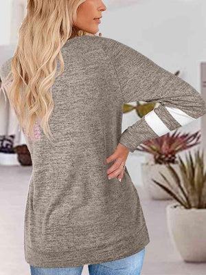 a woman wearing a grey sweater and jeans