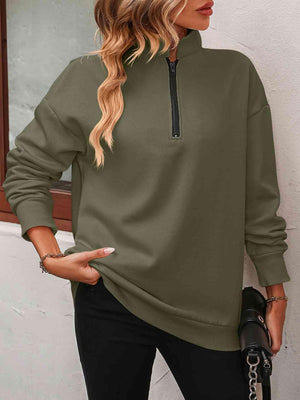 a woman wearing a green sweatshirt and black pants