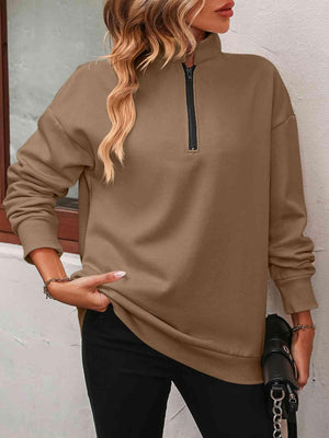 a woman wearing a brown sweatshirt and black pants