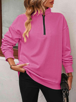a woman wearing a pink sweatshirt and black pants