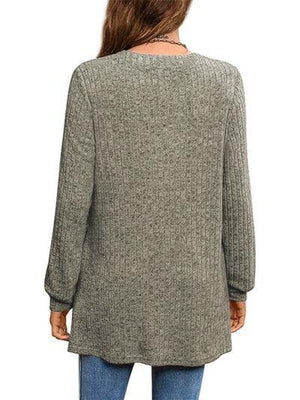 a woman wearing a green sweater and jeans