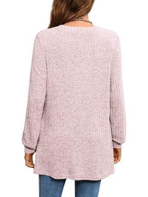 a woman wearing a pink sweater and jeans