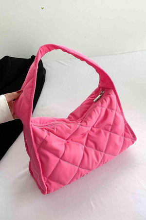 a person holding a pink purse on a bed