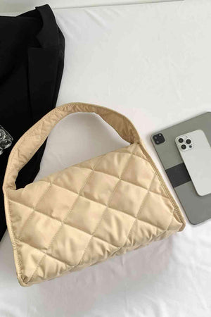 a purse and a cell phone on a bed