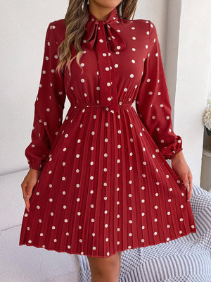 a woman wearing a red dress with white polka dots