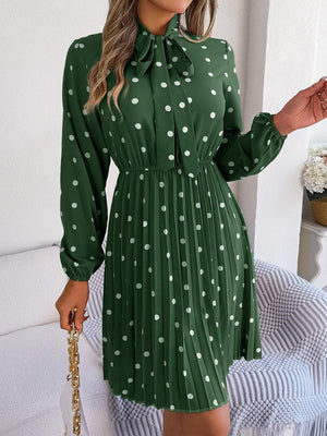 a woman wearing a green dress with white polka dots