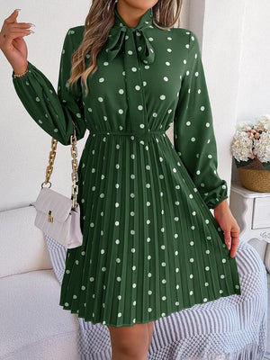 a woman wearing a green dress with white polka dots