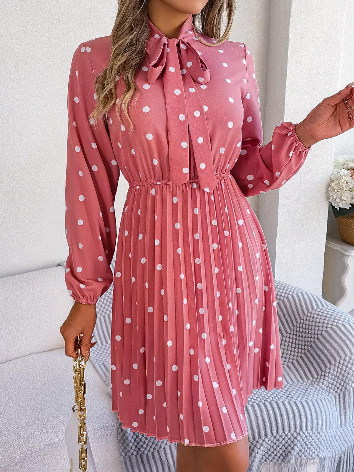 a woman wearing a pink dress with white polka dots