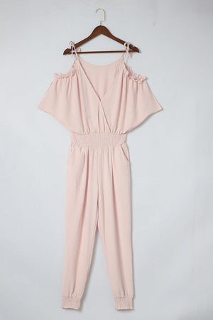 a pink jumpsuit hanging on a hanger