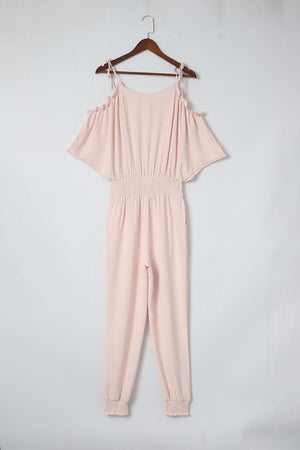 a pink jumpsuit hanging on a hanger