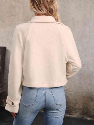 a woman wearing a white jacket and jeans