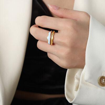 a woman wearing a gold and white ring