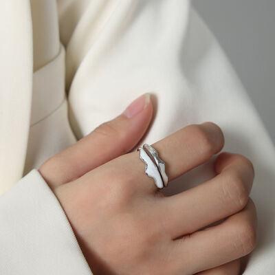 a woman wearing a white shirt and a silver ring