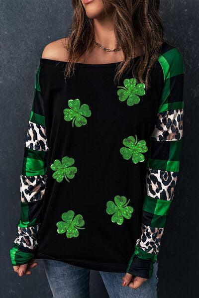 a woman wearing a black top with green shamrocks on it