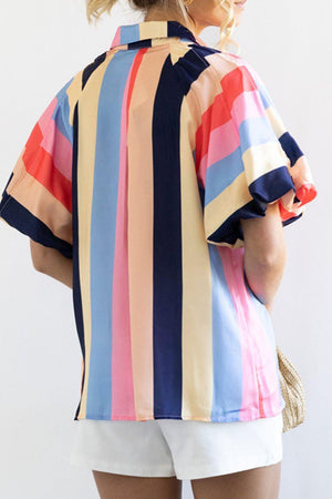 a woman wearing a colorful shirt and white shorts