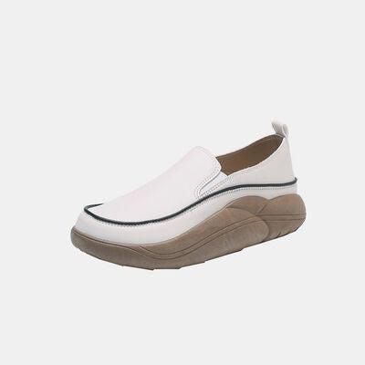 a woman's white shoe with a brown bottom