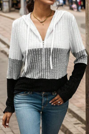 a woman standing next to a pole on a street
