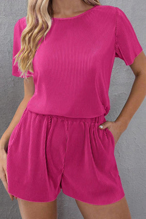 a woman wearing a pink top and shorts