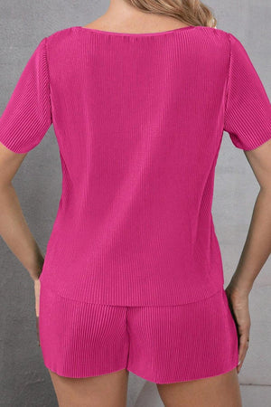 a woman wearing a pink top and shorts