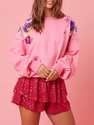 a woman wearing a pink sweatshirt and sequin skirt