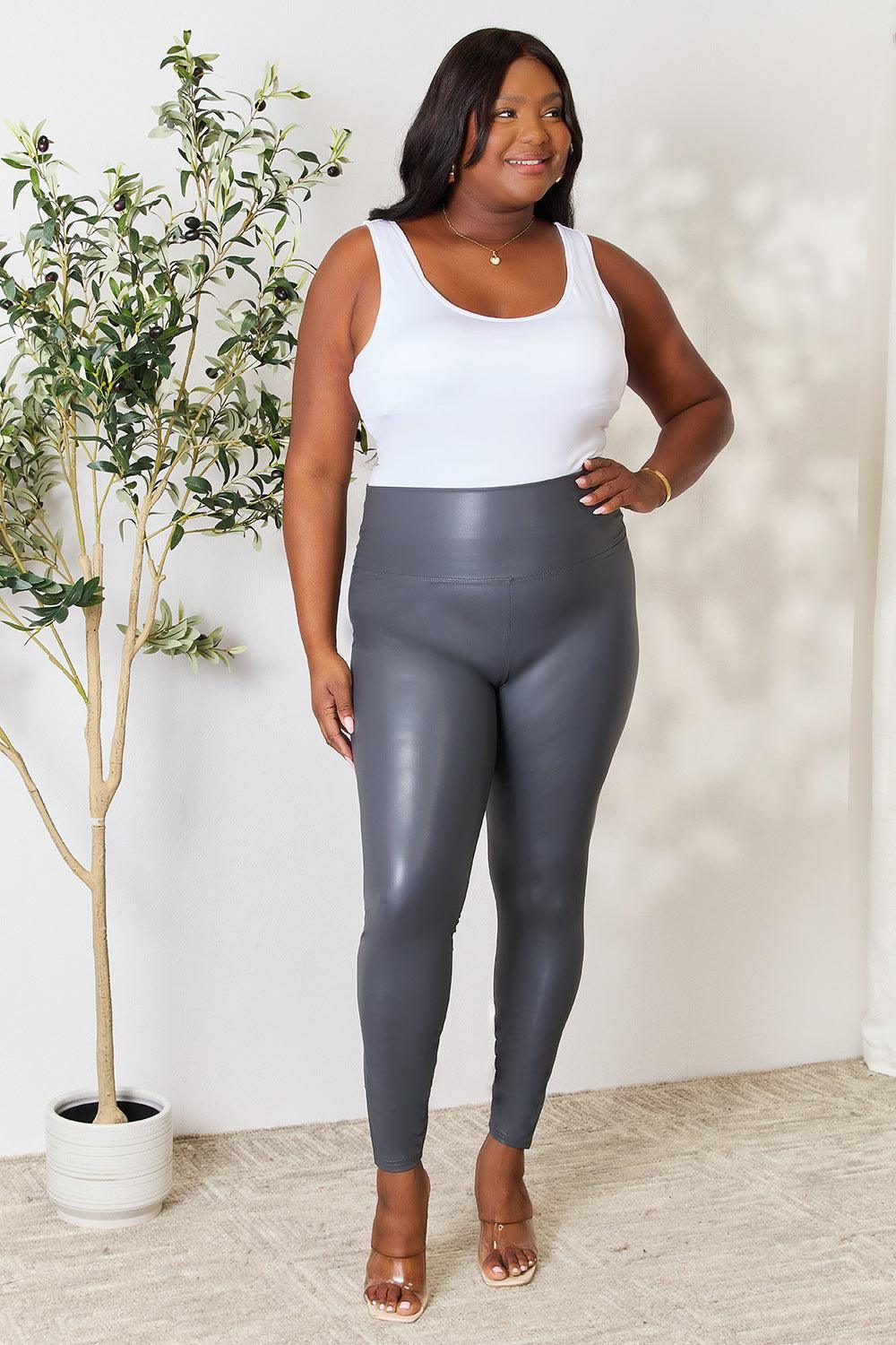 a woman in a white tank top and grey leggings