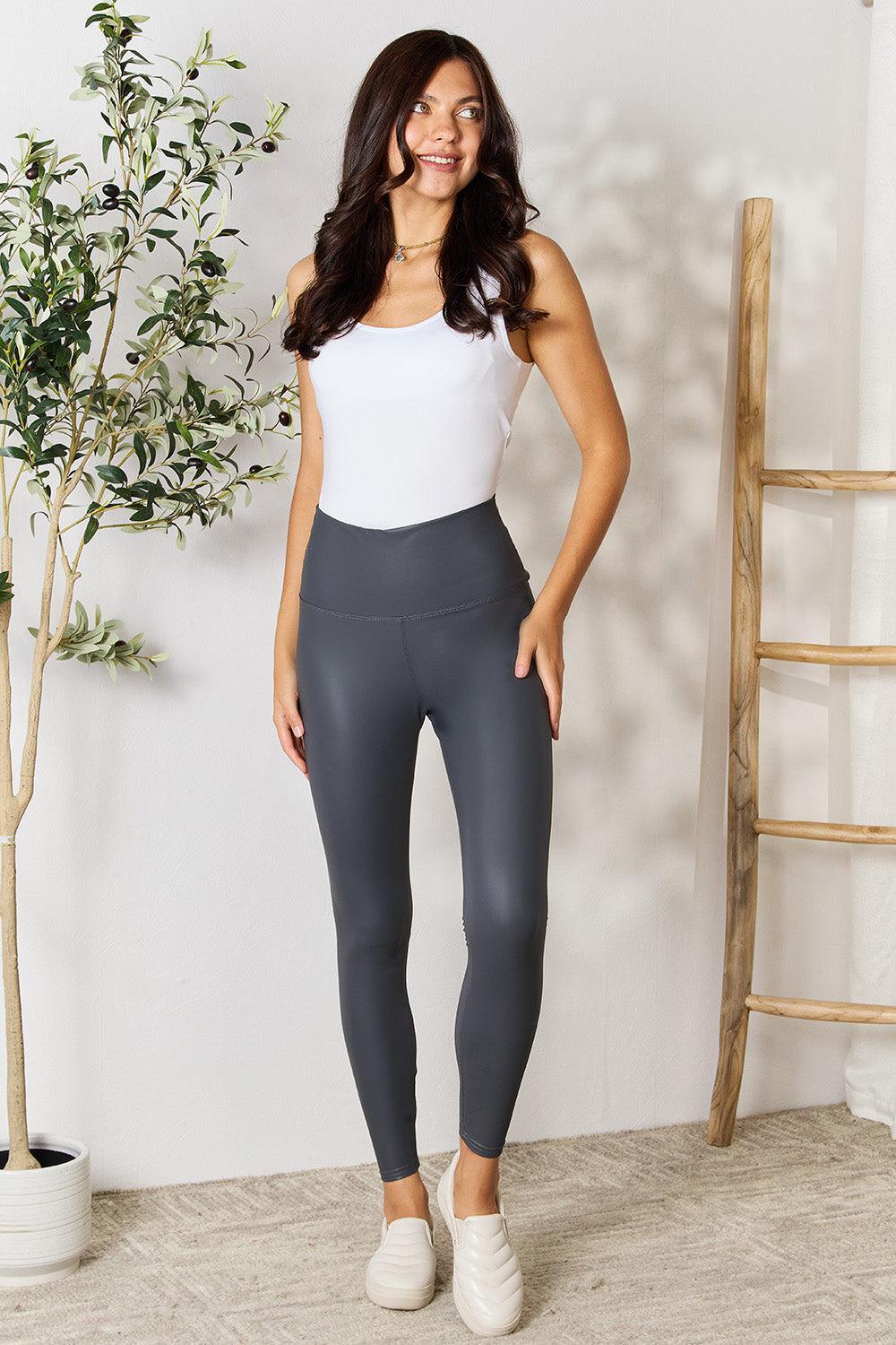 a woman in a white top and grey leggings