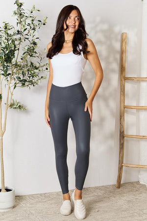 a woman in a white top and grey leggings