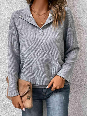 a woman wearing a grey sweater and jeans