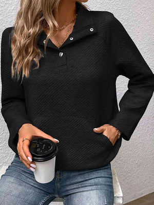 a woman wearing a black sweater and jeans