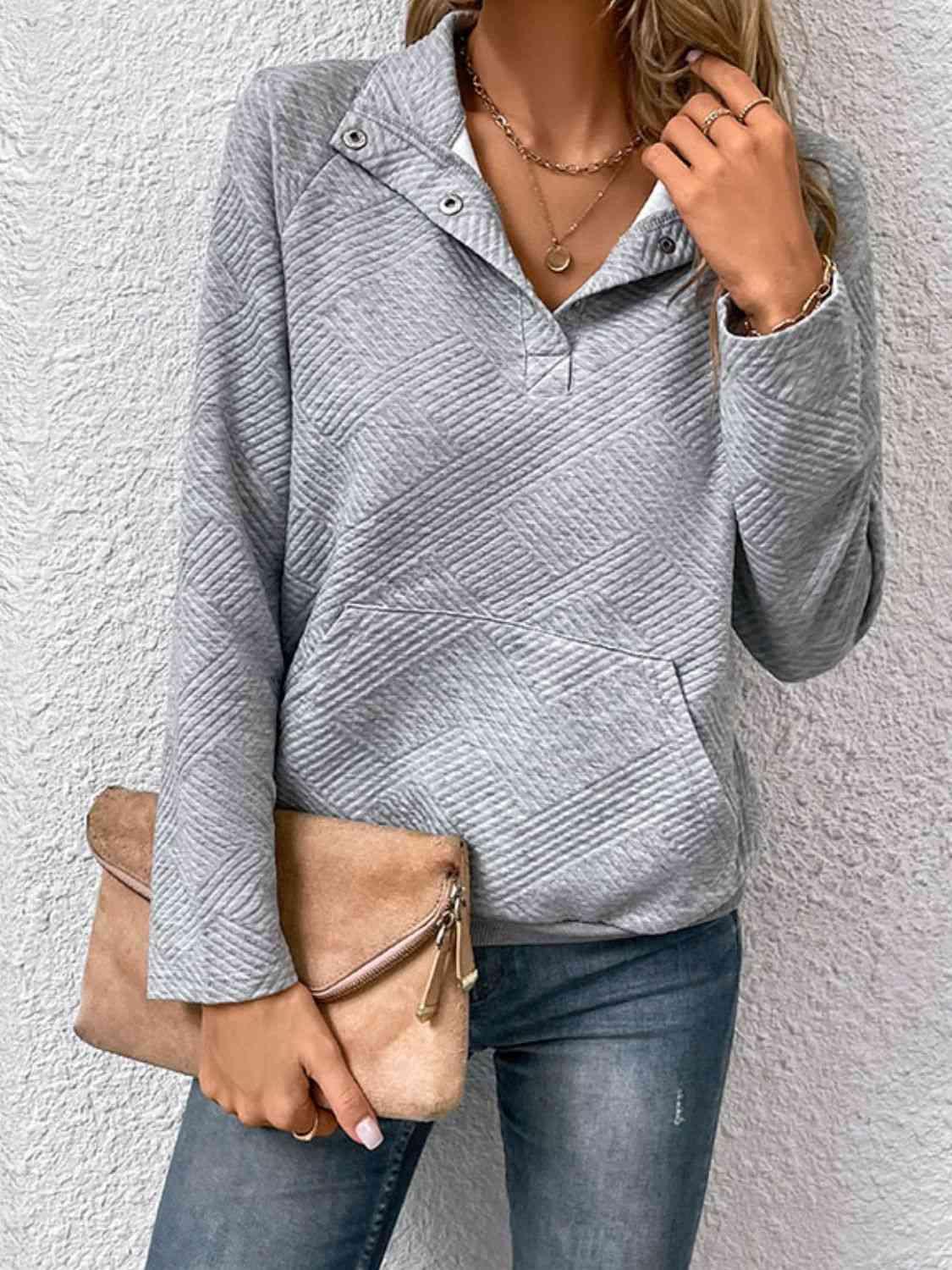 a woman wearing a gray sweater and jeans