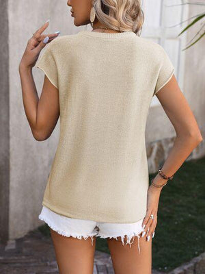 a woman in shorts and a sweater smoking a cigarette