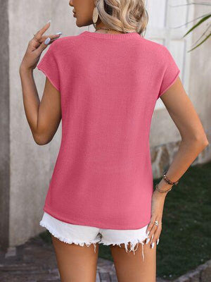 a woman wearing a pink top and white shorts