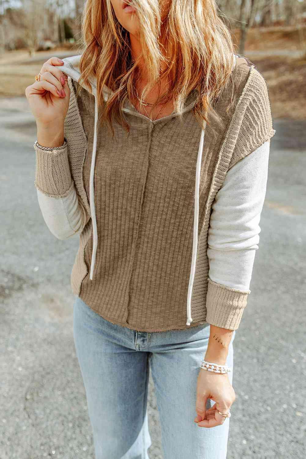 a woman wearing a brown sweater and jeans