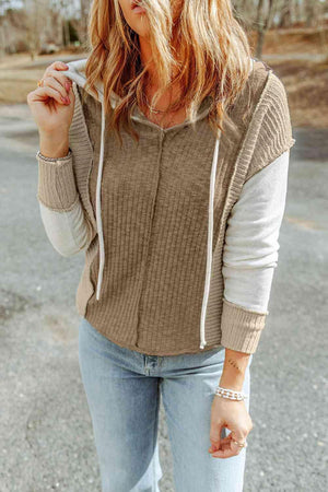 a woman wearing a brown sweater and jeans