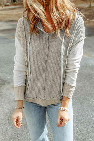 a woman with long hair wearing a sweater and jeans