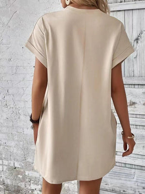 a woman wearing a beige shirt dress