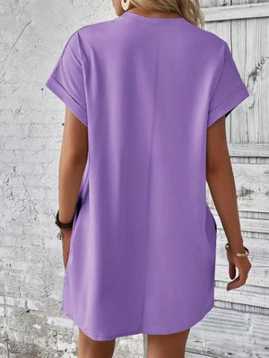 a woman wearing a purple shirt dress