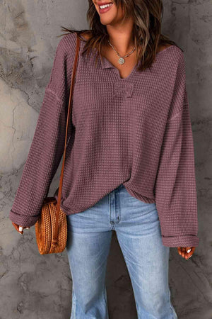 a woman wearing a purple sweater and jeans